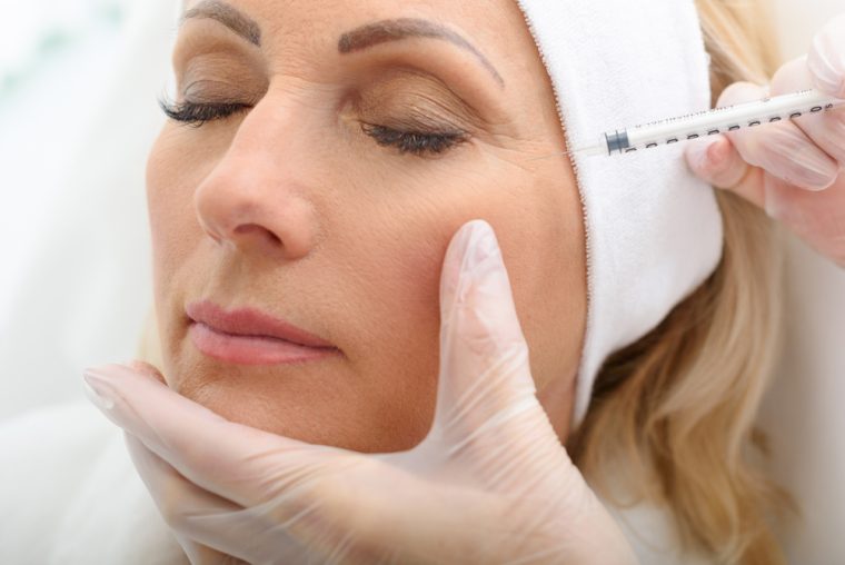 woman treating crow's feet with Botox in Livnoia MI